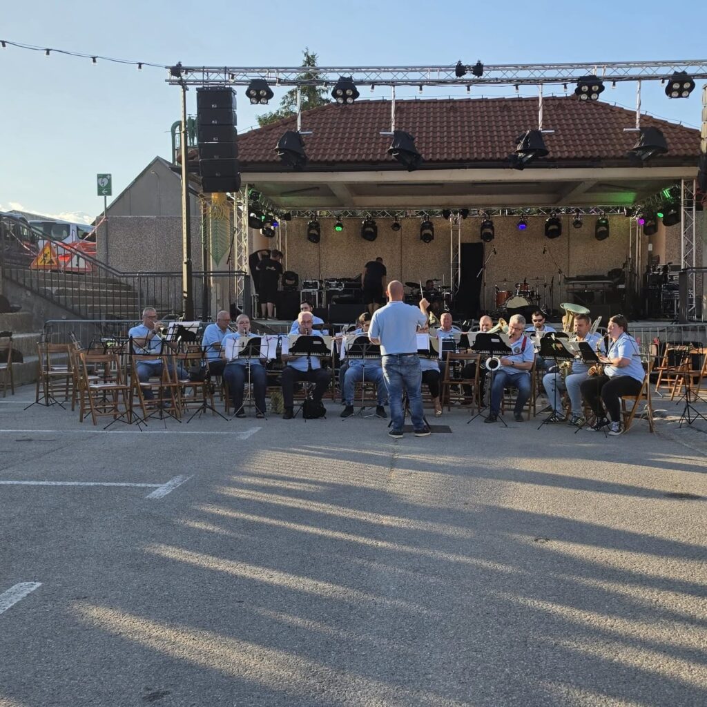 Dirigent vodi puhački orkestar na otvorenoj pozornici